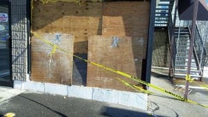 storefront wall boarded up after a collision