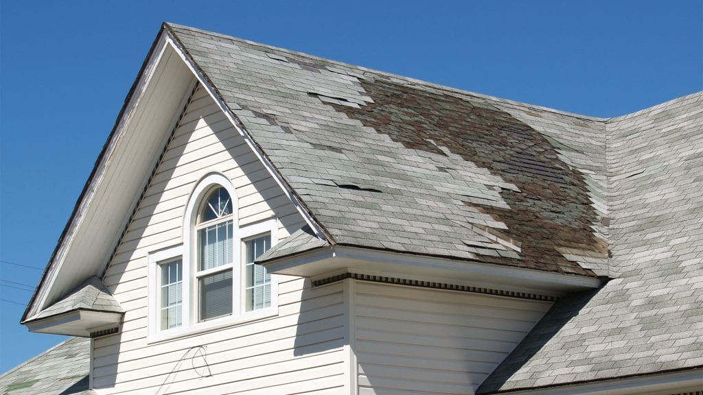 damaged roof tiles on a white house in rhode island