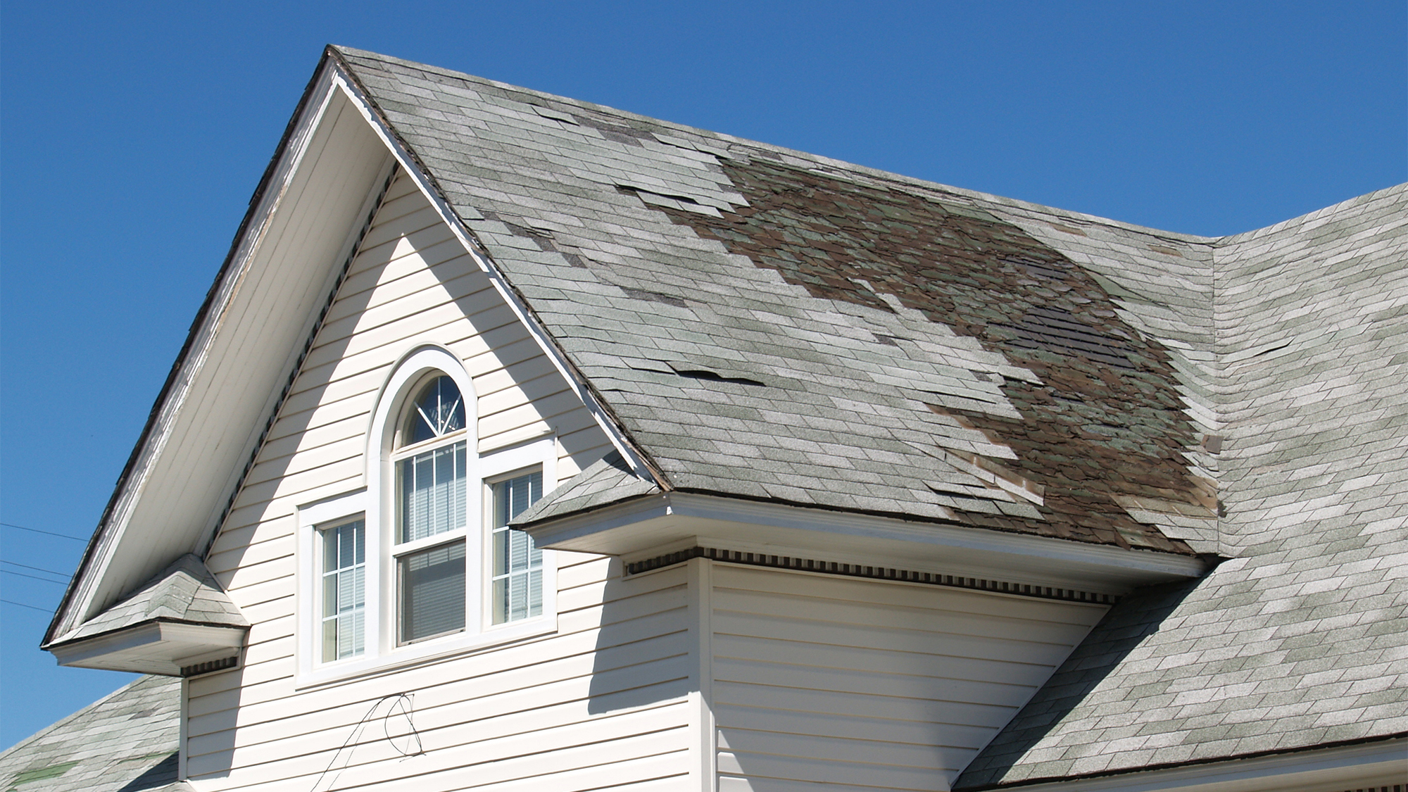 damaged roof tiles on a white house in rhode island