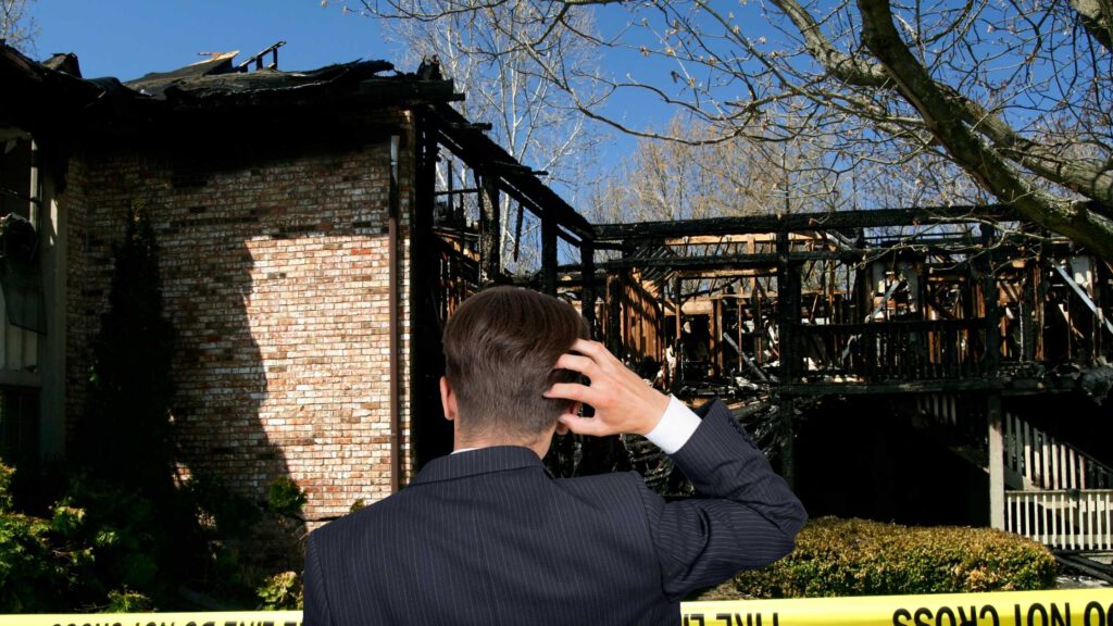 man in suit looking at fire damaged house in rhode island